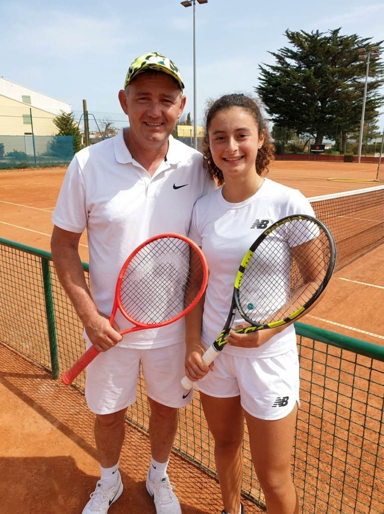 Coach Geoffroy Dupuis with a junior player on a clay tennis court
